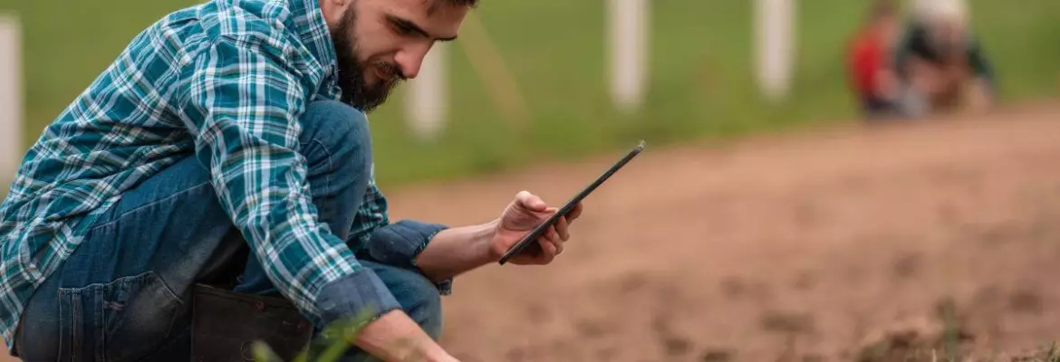 Agricultor comprobando la calidad del suelo tras las prácticas de labranza mínima en un campo ecológico