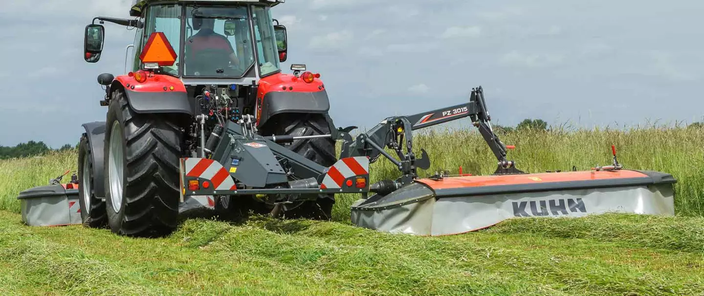 La segadora de tambores PZ 3015 con un tractor Massey Ferguson trabajando con hierba larga