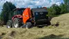 Rotoempacadora de cámara fija FB 3125 de KUHN y, al fondo, el operador en el campo